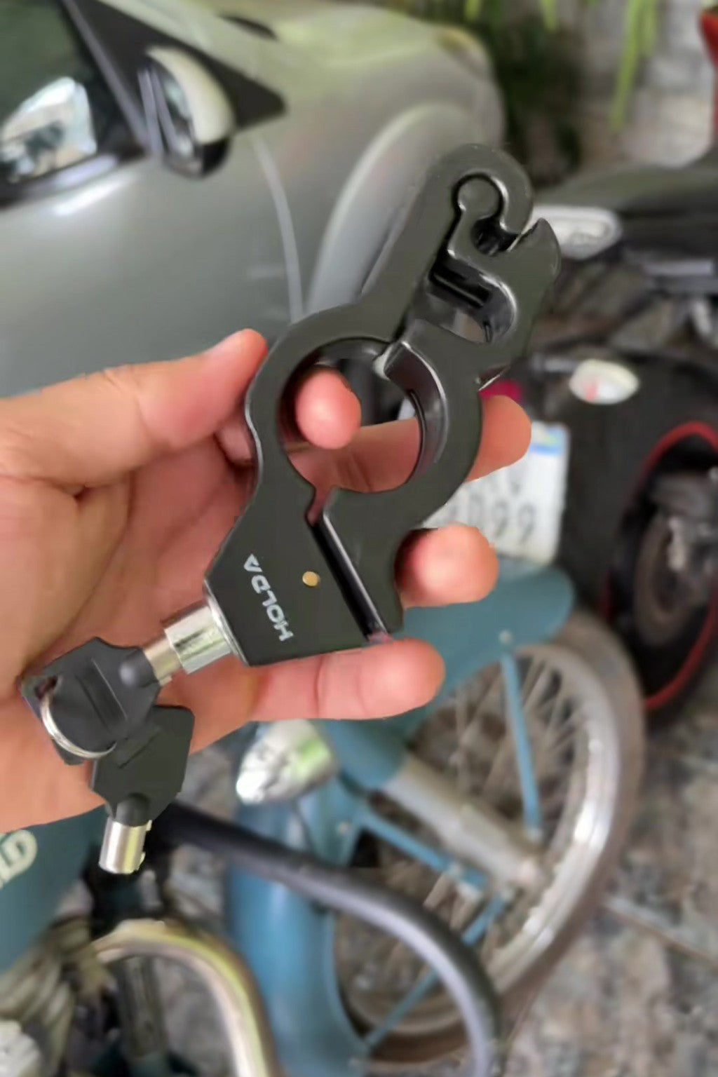 Candado de aluminio con sus llaves en la mano